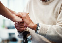 Cropped shot of an unrecognizable female holding her senior parent's hand in comfort